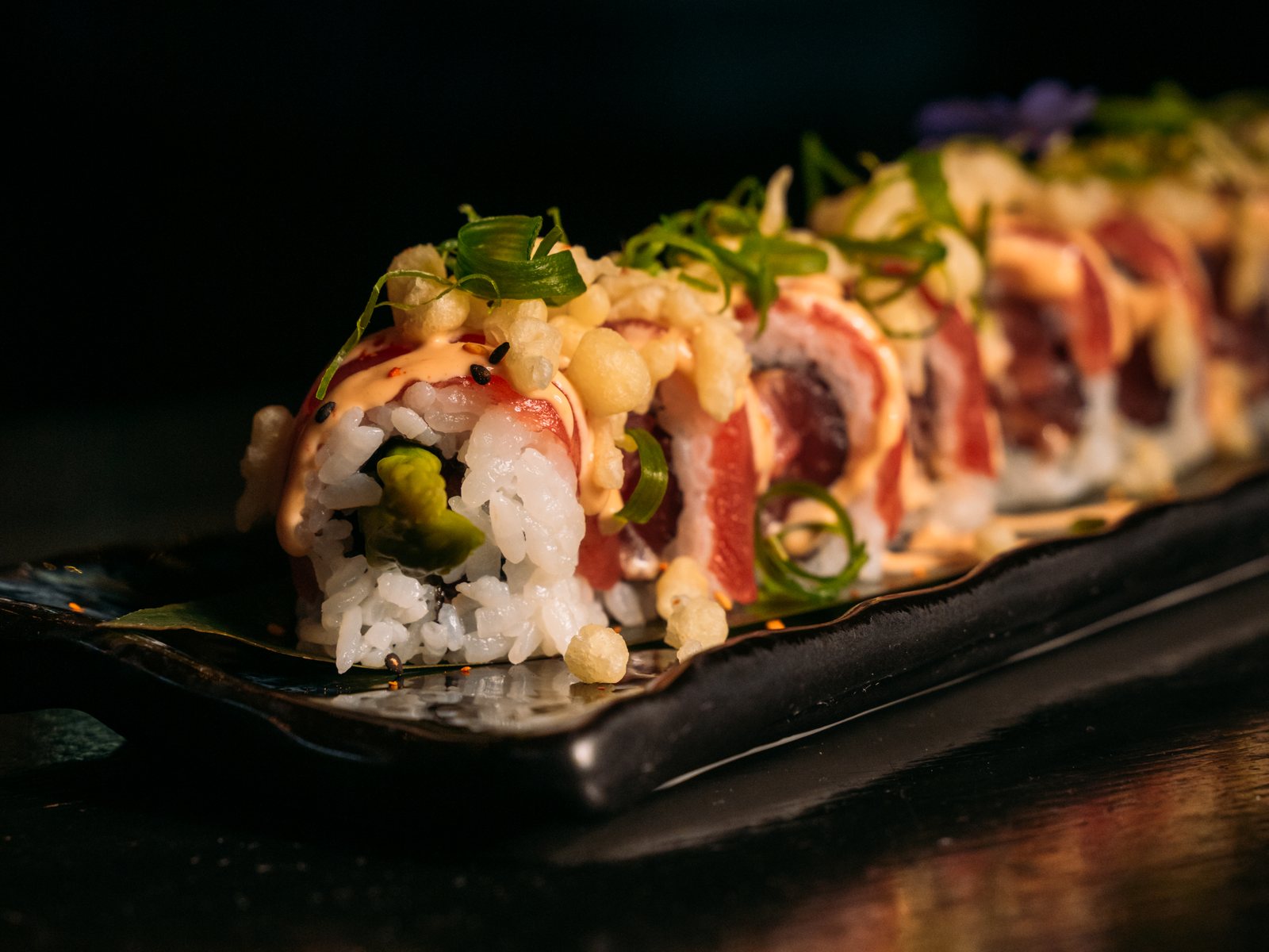 Een sushiroll op een houten plank bij Brasserie Pastis in Rosmalen